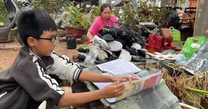 Em Hồ Thiên Long phơi mấy quyển sách vở còn sót lại (Ảnh: Chụp màn hình Thanh Niên)
