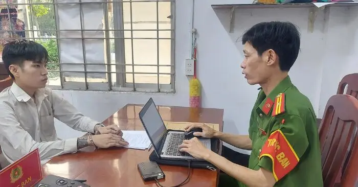 Nguyễn Chí Thiện (trái) tại trụ sở công an (Ảnh chụp màn hình)