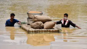 Người dân bang Assam, Ấn Độ vận chuyển lương thực qua vùng ngập lụt bằng bè giữa đợt lũ nghiêm trọng.
